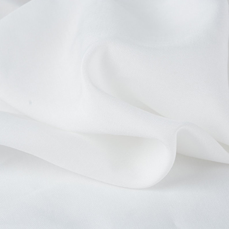 May include: White sheer fabric with a smooth texture and a soft drape.