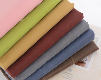 May include: A stack of eight fabric swatches in various colors, including pink, green, brown, red, gray, blue, and brown. The fabric is a textured canvas material.