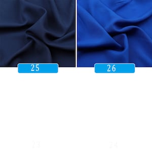 May include: Two fabric swatches, one dark blue and one royal blue. The swatches are folded and the fabric has a smooth texture.