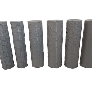 May include: Six grey cylindrical objects with textured surfaces are arranged in a row. The textures vary, including grid-like and organic patterns. The objects are of similar height and diameter, with flat tops.