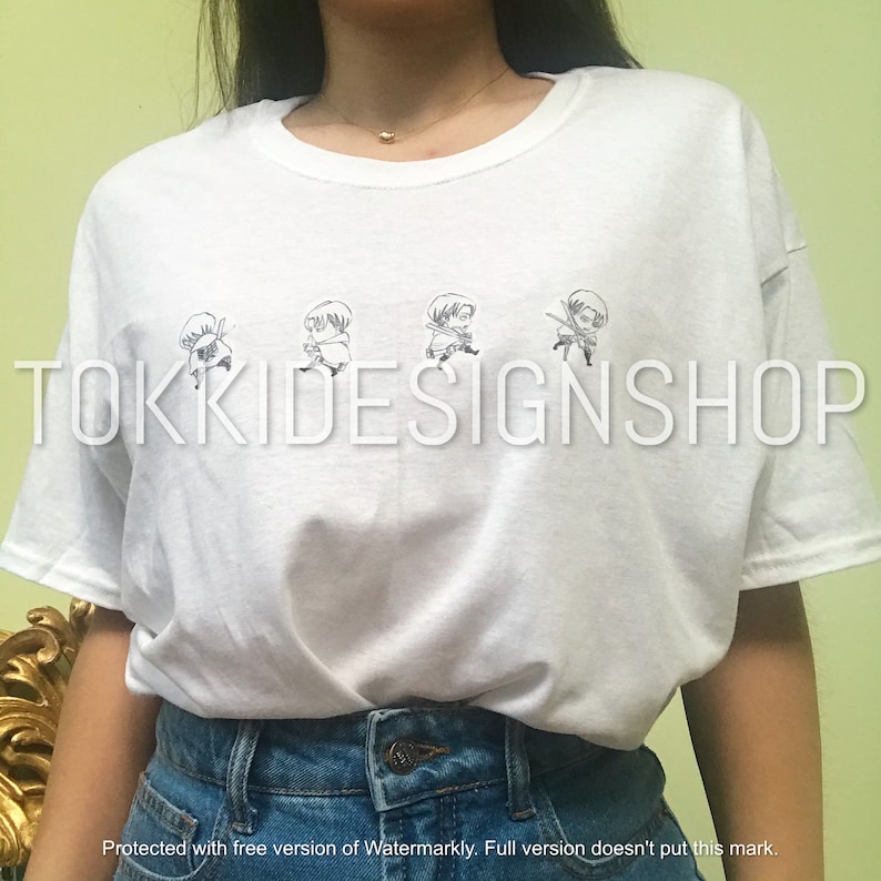 May include: White t-shirt with a black and white graphic print of a cartoon character. The character is shown in four different poses. The text "TOKKIDESIGNSHOP" is printed on the shirt.