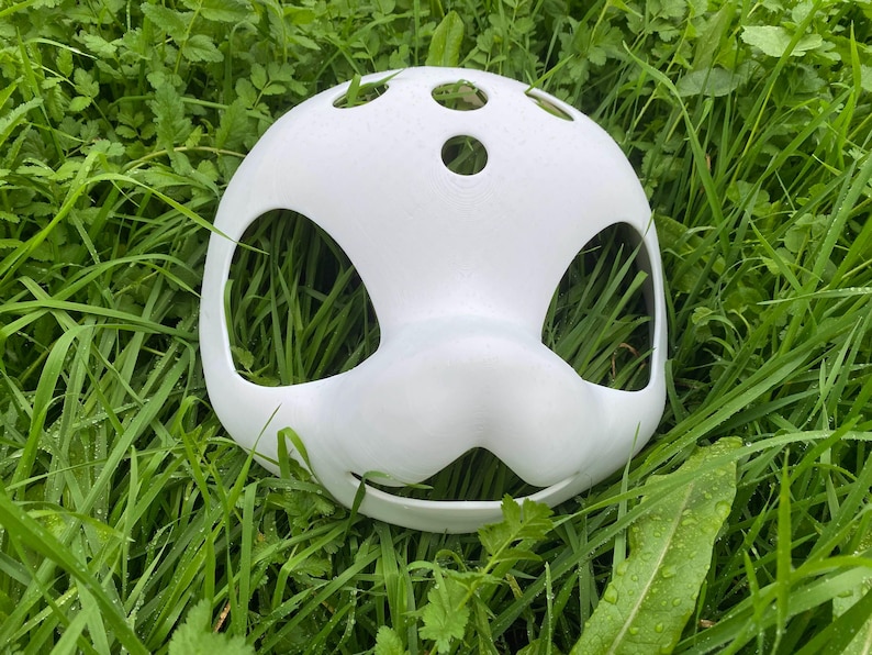 May include: White plastic mask with large eye holes and a small mouth hole. The mask has several small holes on the top.