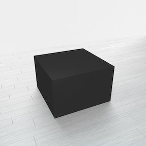May include: A black square pedestal or platform, likely made of wood or plastic, sits on a white wood floor. It is a simple, minimalist design, perfect for displaying products or showcasing items.
