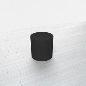 May include: A black cylindrical pedestal, standing on a white wood floor.