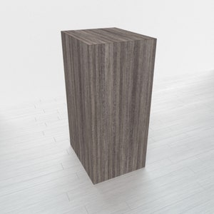 May include: A dark gray wooden pedestal with a smooth, textured surface. The pedestal is rectangular in shape and has a modern, minimalist design.