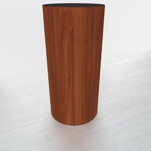 May include: A round wooden pedestal with a dark brown wood grain finish. The pedestal is about 12 inches tall and 10 inches in diameter.