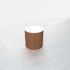 May include: A wooden cylinder with a white top, perfect for displaying products or showcasing small items.