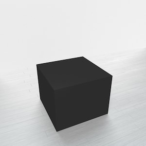 May include: A black square pedestal or platform, made of a smooth material, sits on a white wood floor.