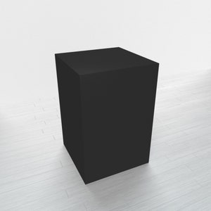 May include: A black square pedestal or display stand, made of a solid material, sits on a white wood floor.