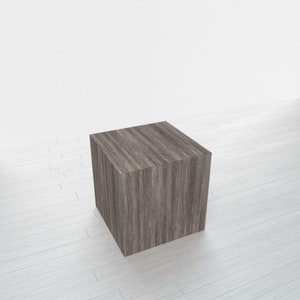 May include: A dark brown wooden cube with a wood grain pattern. The cube is sitting on a white surface.