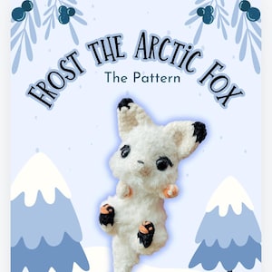 Puede incluir: Un zorro ártico de crochet blanco con orejas y patas negras. El zorro está sentado sobre un fondo nevado con árboles azules. El texto "Frost the Arctic Fox The Pattern" está escrito en azul y blanco en la parte superior de la imagen.