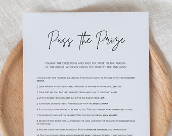 Op de afbeelding: Een witte kaart met zwarte tekst die "Pass the Prize" zegt. De kaart bevat instructies voor een spel waarbij spelers een prijs doorgeven aan de persoon die aan de beschrijving in elk rijmpje voldoet.