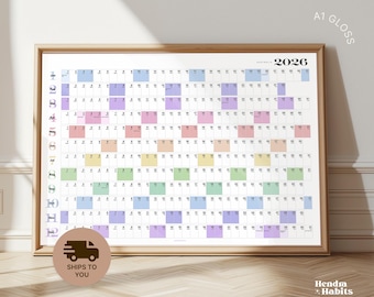 Puede incluir: Calendario anual enmarcado de 2026 con un diseño colorido. El calendario está etiquetado como "Australia" y presenta una cuadrícula de fechas con cada mes en un color pastel diferente. El marco es de madera clara.