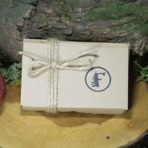 May include: A brown cardboard box tied with twine and a bow. The box has a logo with a stylized tree and the letter "F" in a circle.