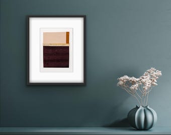 Puede incluir: Impresión artística abstracta enmarcada, con un collage de texturas y colores. La obra de arte tiene una sección superior beige claro, una sección inferior burdeos oscuro y una fina franja vertical naranja. La impresión está en un marco negro.