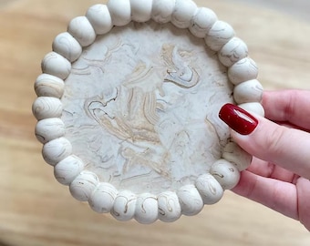 Bandeja decorativa neutra con burbujas: Plato para velas con efecto mármol para una decoración moderna del hogar.
