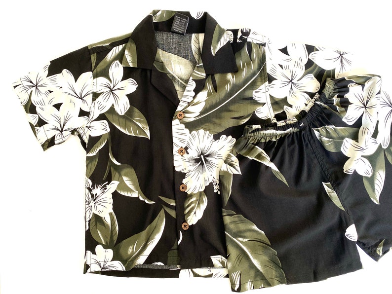 May include: A black and green Hawaiian shirt and shorts set with a white floral print.