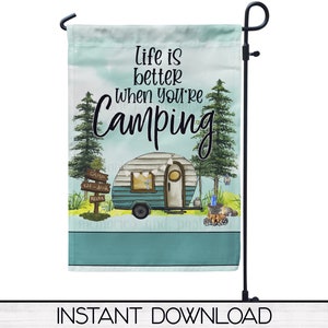 May include: A teal blue and white garden flag with the text "Life is better when you're camping" and a cartoon illustration of a camper van in a forest setting.