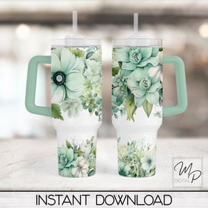 May include: Two stainless steel tumblers with a green floral design and a green handle. The tumblers have a white background and a clear lid with a straw.