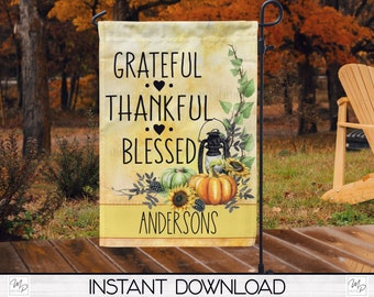 Può includere: Una bandiera da giardino con le parole "Grateful, Thankful, Blessed" in corsivo nero. La bandiera presenta uno sfondo in stile acquerello con zucche, girasoli e una lanterna. Il nome "Andersons" è stampato in basso.