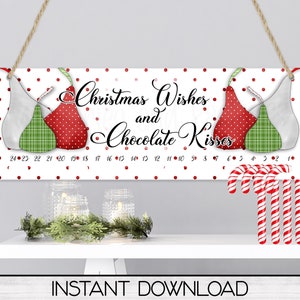 May include: A white sign with red polka dots and two red and green pear-shaped ornaments. The sign says "Christmas Wishes and Chocolate Kisses" with the numbers 24 to 1 printed below.  There are red and white candy canes hanging from the bottom of the sign.