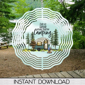 May include: A teal blue metal wind spinner with a white background and the text "Life is better when you're camping". The design features a vintage camper, trees, and a campfire.
