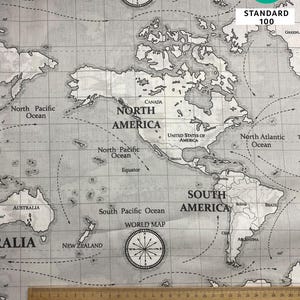 May include: Gray and white world map fabric with compass rose details and country names. The fabric includes the text "OEKO-TEX STANDARD 100". A wooden ruler is placed at the bottom of the image.