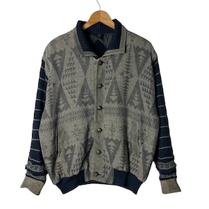 May include: A gray and black patterned bomber jacket with a blue knit collar and cuffs. The jacket has a button closure and two pockets.