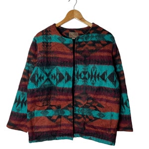 May include: A brown, teal, and black patterned cardigan with a button closure. The cardigan has two pockets on the front.