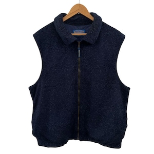 Puede incluir: Un chaleco de forro polar azul marino con cremallera completa y cuello. El chaleco está colgado de una percha de madera sobre un fondo blanco. La marca "Pendleton" es visible en el cuello.