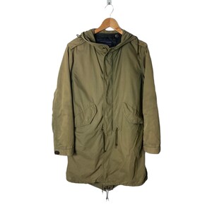 Puede incluir: Una parka verde con capucha, cintura con cordón y cierre de cremallera. La parka tiene un bolsillo con solapa en el pecho y dos bolsillos en los laterales.
