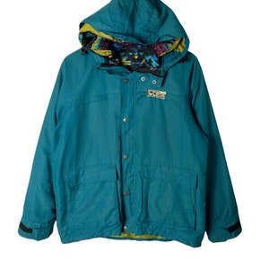 May include: Teal blue hooded jacket with a colorful patterned lining and a black logo patch that says "Sierra Designs" on the left chest.