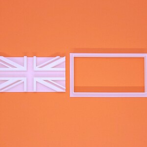 May include: A white Union Jack flag and a rectangular frame, set against an orange backdrop. The flag is a simplified design of the UK flag. The frame is a plain, empty rectangle.