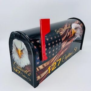 May include: Black mailbox with an American flag design featuring bald eagles and the text "God Bless America". The mailbox has a red flag and the address "127 Captiva St. Caldwell's"