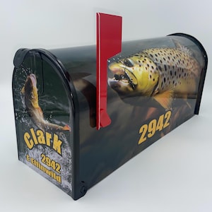 May include: A black mailbox with a colorful image of a trout jumping out of the water. The mailbox has a red flag and the name "Clark" and the number "2942" printed on it.