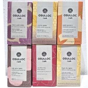 Könnte beinhalten: Sechs Schachteln Osulloc-Teebeutel, jede mit einem anderen Geschmack. Die Geschmacksrichtungen sind: Feigen-Schokoladen-Schwarztee, Süßer Honig-Schwarztee, Mandarinenblüten-Tee, Maronen-Glace-Schwarztee, Süßer Hibiskus und Vanille-Honig-Schwarztee. Jede Schachtel ist 30 Gramm schwer und enthält 20 Teebeutel.