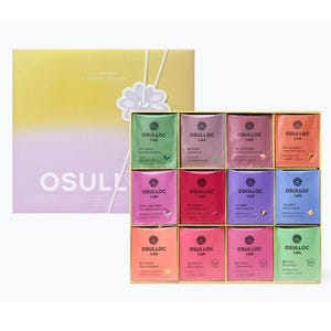 Könnte beinhalten: Ein Geschenkset mit einem gelb-violetten Farbverlauf auf dem Deckel, einer weißen Blumenapplikation und dem Schriftzug OSULLOC. Im Inneren befinden sich zwölf einzelne Teebeutel in verschiedenen Farben, jeweils mit der Marke OSULLOC und Sorte.