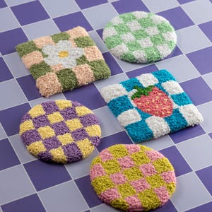 May include: Five colourful round and square crocheted coasters with checkered patterns. The coasters feature a flower, a strawberry, and different colour combinations of yellow, green, pink, purple, and blue.
