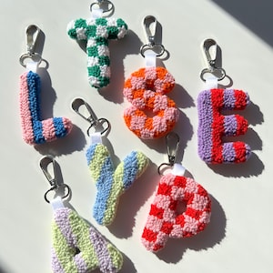 Peut inclure: Collection de porte-clés lettres faits à la main. Chaque lettre est fabriquée avec un matériau texturé semblable à du fil et comporte un fermoir argenté. Les lettres comprennent L rose et bleu, T vert et blanc, S orange et rose, E rouge et violet, A vert et violet, Y bleu et jaune et P rouge et rose.