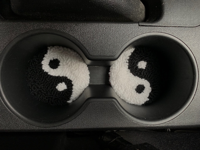 Peut inclure: Deux porte-gobelets de voiture yin yang noir et blanc. Les porte-gobelets sont faits d'un mat&eacute;riau doux et duveteux.
