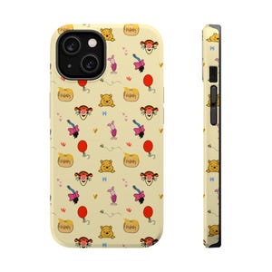 Könnte beinhalten: Eine gelbe iPhone-Hülle mit einem sich wiederholenden Muster von Zeichentrickfiguren, darunter Winnie Puuh, Ferkel, Tiger und rote Luftballons. Die Hülle hat eine glänzende Oberfläche und ein schwarzes Kameramodul.