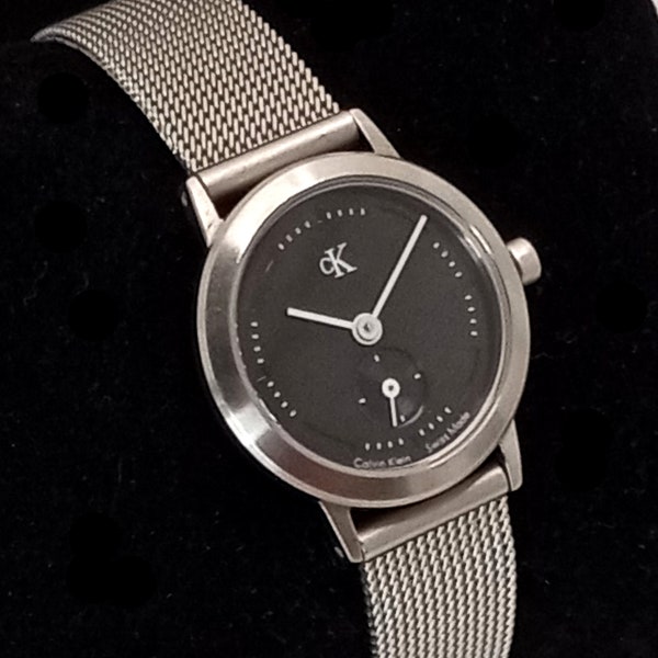 vintage Femme Calvin Klein CK Swiss Made Montre en maille d’acier inoxydable Cadran noir Ton argenté Fonctionnant!