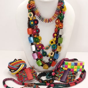 Peut inclure: Un ensemble de colliers et de bracelets en perles de bois colorés. Les colliers sont superposés et présentent des perles de différentes formes et tailles, notamment des cercles, des carrés et des fleurs. Les bracelets sont également en perles de bois et présentent une variété de couleurs et de motifs.