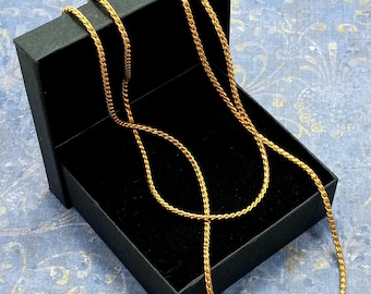 May include: Two gold rope chains in a black velvet box. The chains are made of a twisted rope design.