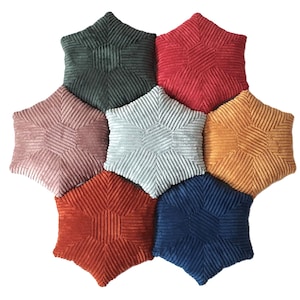 May include: Eight star-shaped cushions in a variety of colours, including green, red, pink, light blue, orange, and navy blue. Each cushion has a ribbed texture and a geometric design.