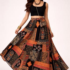 Pode incluir: Uma caneca de cerâmica branca com uma alça preta e o texto "But First, Coffee" em negrito preto. A caneca está sobre um fundo desfocado, sugerindo um ambiente acolhedor.