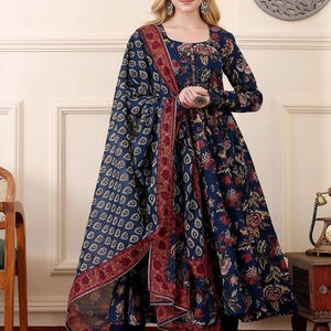 May include: A navy blue floral print dress with a matching shawl. The dress features long sleeves and a round neckline. The shawl has a patterned design with a burgundy border. The outfit is suitable for special occasions.