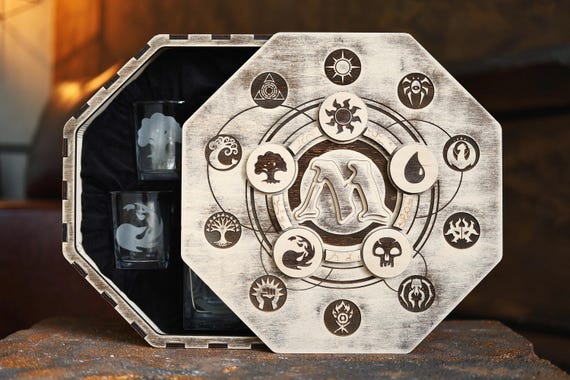 A Magic: The Gathering–themed engraved whiskey decanter set — niche fandom meets grownup barware in a way that'll make an MTG player actually gasp.