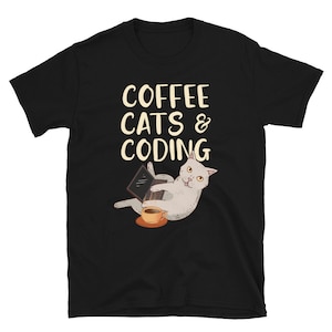 May include: Black t-shirt featuring a white cat sitting on a laptop with a cup of coffee. The text "Coffee Cats & Coding" is printed on the shirt.