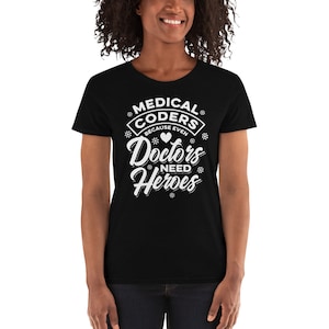 May include: Black t-shirt with white text that reads "Medical Coders Because Even Doctors Need Heroes". The text is in a stylised font with a heart symbol.